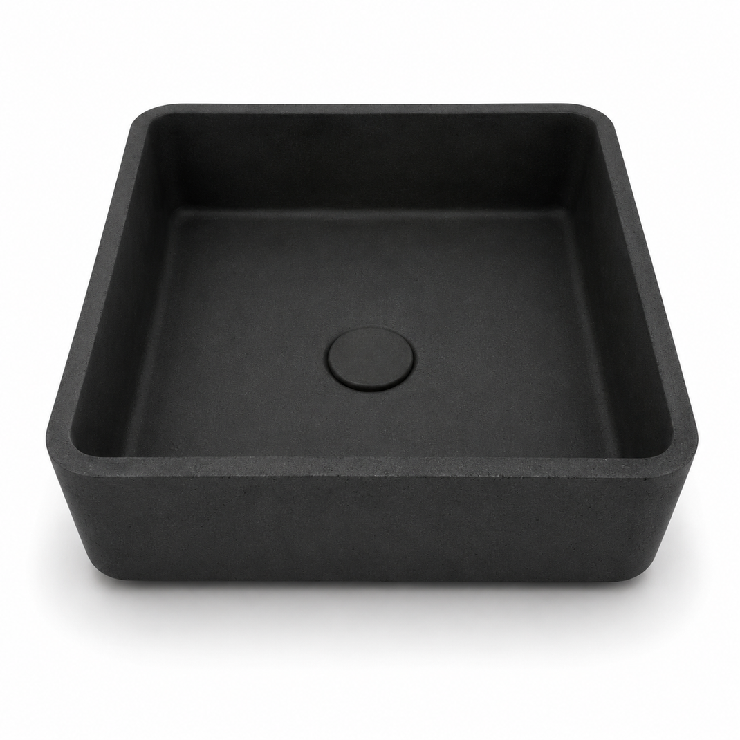 Square concrete vessel sink on a gray stone vanity with matte black wall-mounted faucet and modern bathroom decor.