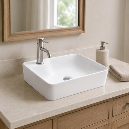 White compact rectangular ceramic countertop basin styled on a stone vanity with brushed nickel faucet, mirror, and towel