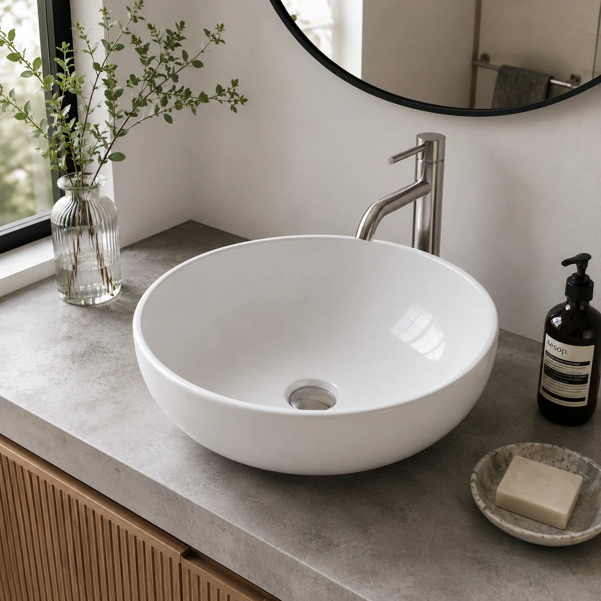 Small round ceramic vessel sink installed in a styled bathroom — lifestyle scene, SANIKB SN129.