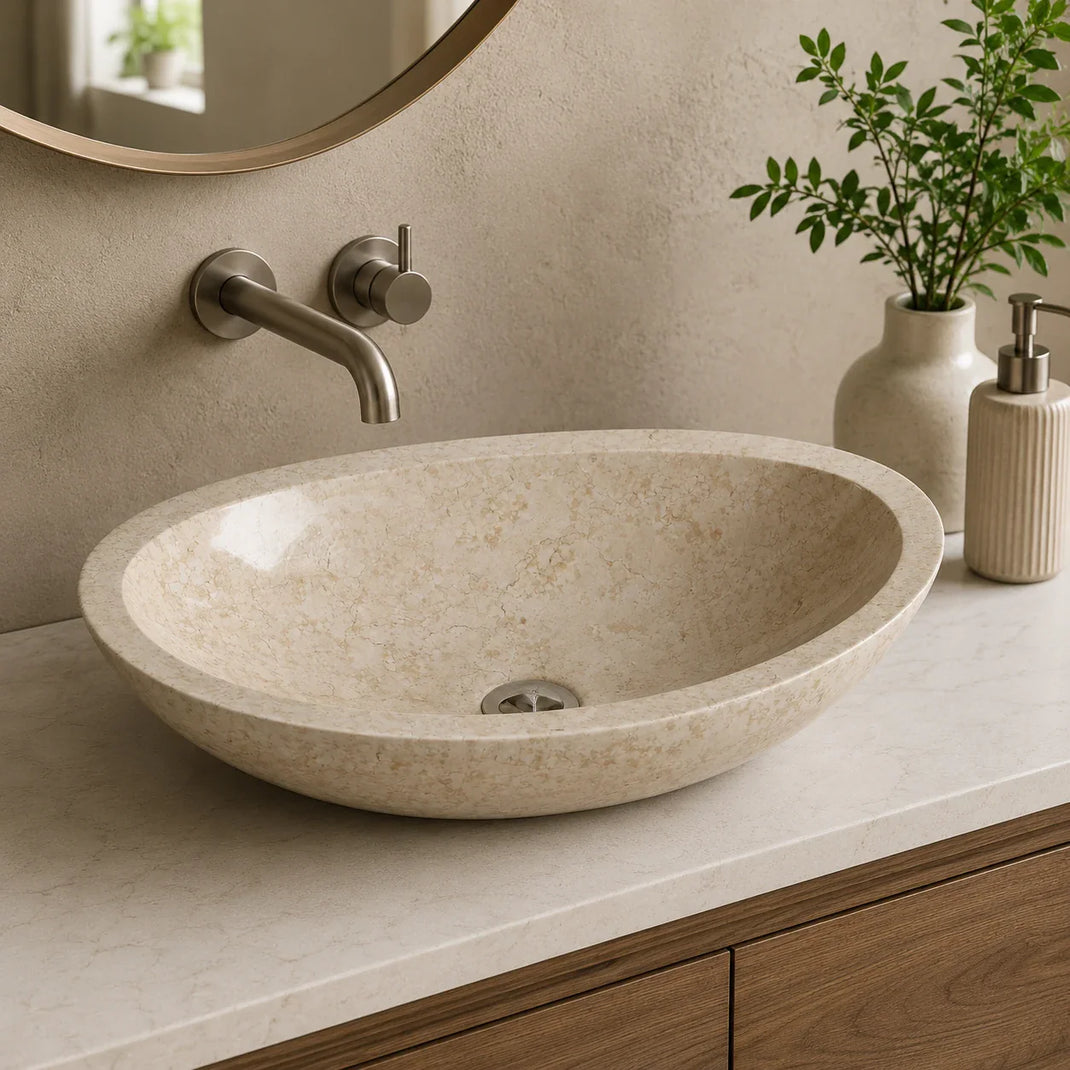 Beige marble oval stone vessel basin styled in a modern bathroom