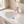 White oval undermount bathroom sink installed in a marble-look vanity top with a chrome single-hole faucet