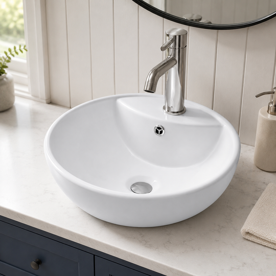 White 18 inch round ceramic vessel sink installed on a vanity top with a single-hole vessel faucet in a modern bathroom