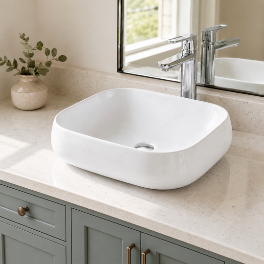 White rounded rectangular ceramic vessel sink installed above-counter on a stone vanity top with a chrome faucet