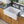 White fireclay apron-front farmhouse sink installed in a wood-cabinet kitchen — SANIKB SNT3020H