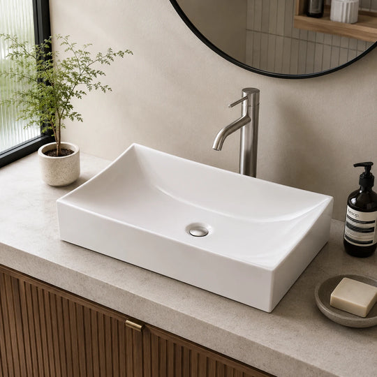 Curved rectangular ceramic vessel sink installed in a styled bathroom — lifestyle scene, SANIKB SN148.