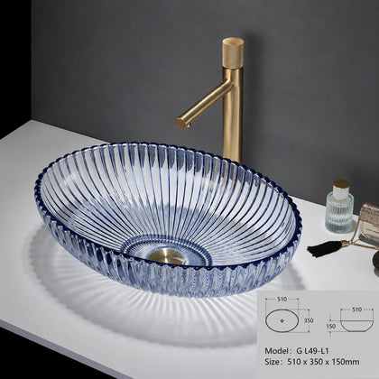 Clear glass oval vessel sink with blue rim and gold faucet, 510mm bowl