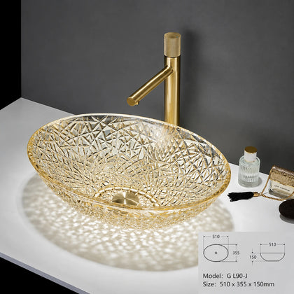 Clear gold-rimmed faceted glass vessel sink with gold faucet, oval bowl