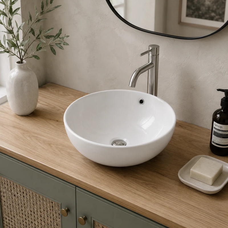 Round ceramic vessel sink with overflow installed in a styled bathroom — lifestyle scene, SANIKB SN127-516.